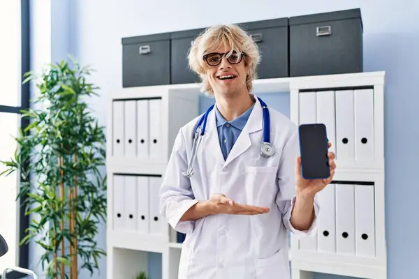 Young Doctor Man Showing Smartphone Screen Looking Positive Happy Standing — Stock Photo, Image