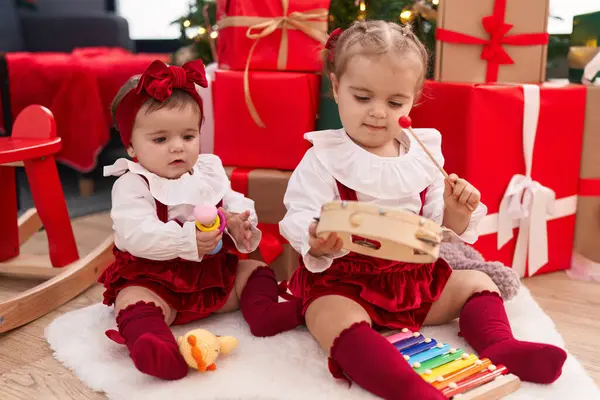 自宅でクリスマスを祝うキシロフォンとタンバリンを演奏する愛らしい女の子 — ストック写真