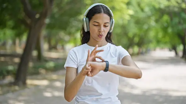 African american woman using watch listening to music at park