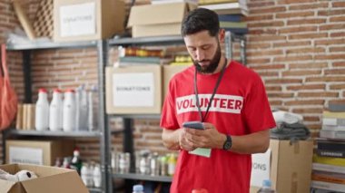 Genç İspanyol gönüllü yardım merkezinde akıllı telefon kullanıyor.