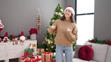 Genç ve güzel İspanyol kadın Noel 'i evde dans ederek kutluyor.
