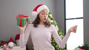 Genç, güzel, İspanyol bir kadın Noel ağacının yanında dans ediyor.