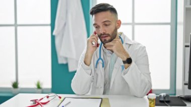 Genç İspanyol doktor akıllı telefondan konuşuyor. Klinikte nöbet tutuyor.