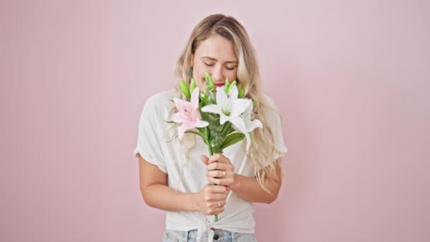 Młoda Blondynka Kobieta Uśmiechnięta Pewnie Gospodarstwa Bukiet Kwiatów Odizolowanym Różowym — Wideo stockowe