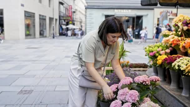 在维也纳的街道上 年轻美丽的惊慌失措的女人触摸着五彩缤纷的花朵 — 图库视频影像
