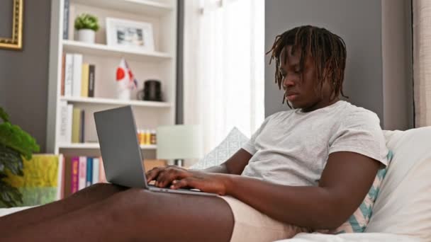 Hombre Afroamericano Usando Portátil Sentado Cama Cansado Dormitorio — Vídeo de stock