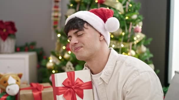 Jeune Homme Hispanique Souriant Confiant Tenant Cadeau Noël Maison — Video
