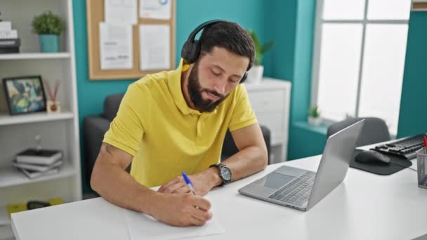 Joven Trabajador Negocios Hispano Usando Laptop Auriculares Tomando Notas Oficina — Vídeos de Stock