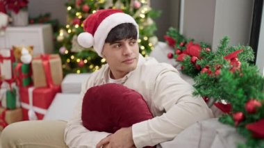 Genç İspanyol adam gülerek Noel 'i evde kutluyor.