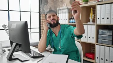 Genç İspanyol doktor akıllı telefondan konuşuyor. Klinikte röntgen çekiyor.