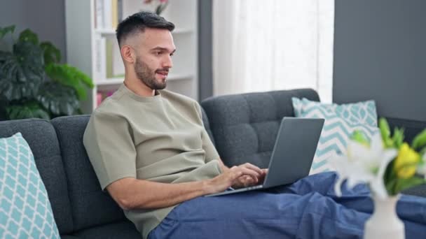 Young Hispanic Man Using Laptop Sitting Sofa Home — стоковое видео