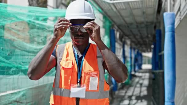 Afrikanisch Amerikanischer Bauarbeiter Lächelt Selbstbewusst Mit Bollenhut Auf Baustelle — Stockvideo