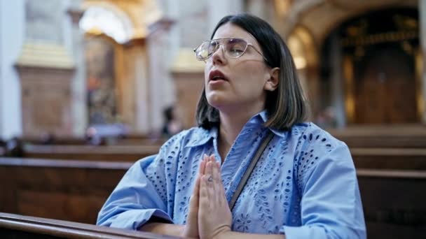 年轻美丽的惊慌失措的女人在教堂的长椅上祈祷 — 图库视频影像