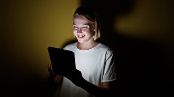 Młoda Blondynka Uśmiecha Się Pewnie Używając Touchpad Świętując Odizolowanym Żółtym — Wideo stockowe