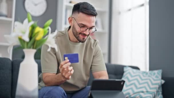 Ung Latinamerikansk Man Shoppa Med Touchpad Och Kreditkort Sitter Soffan — Stockvideo