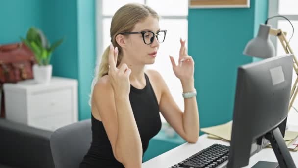 若い金髪女性ビジネスワーカーは オフィスで勝者のジェスチャーでコンピュータを見ている指を横断 — ストック動画