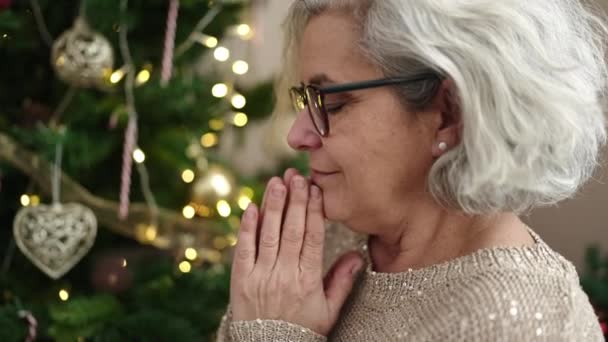 Kobieta Średnim Wieku Siwymi Włosami Siedząca Przy Choince Modląca Się — Wideo stockowe