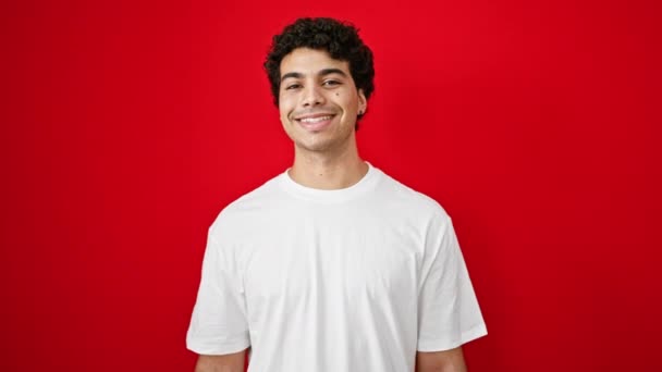 Mladý Latinsky Muž Usmívá Sebevědomě Dělá Vojenský Pozdrav Přes Izolované — Stock video