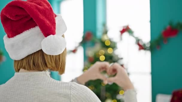 Joven Mujer Rubia Sonriendo Por Árbol Navidad Haciendo Forma Corazón — Vídeos de Stock