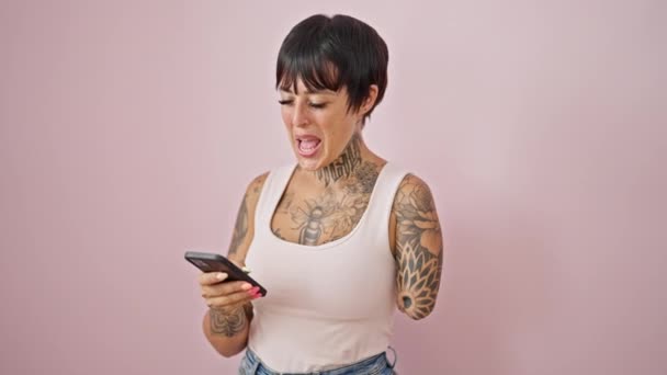 Іспанська Жінка Ампутаційною Рукою Допомогою Смартфона Посміхаючись Над Ізольованим Рожевим — стокове відео