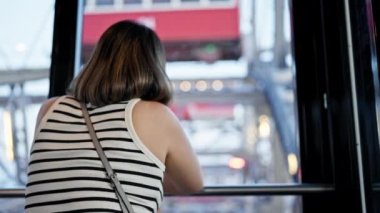 Genç ve güzel İspanyol bir kadın büyük bir tekerlekle Prater Viyana 'nın manzarasına bakıyor.