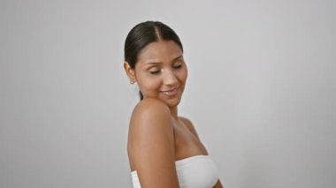 İzole edilmiş beyaz arka planda duran kendine güvenen genç Latin kadın.