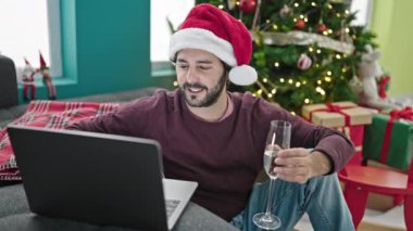 Genç İspanyol adam Noel 'i evde şampanyayla kutluyor.