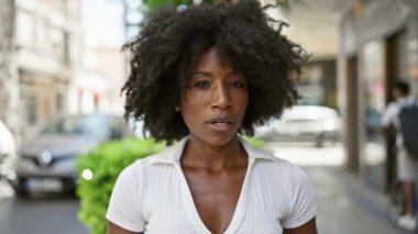 Sokakta ciddi bir ifadeyle duran Afrikalı Amerikalı kadın.