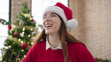 Genç İspanyol kadın Noel 'i evde gülümseyerek kutluyor.