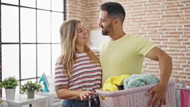 男性と女性のカップルは洗濯室で服を着てお互いを抱き合って — ストック動画