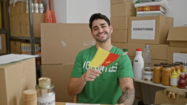 Jovem Hispânico Voluntário Sorrindo Confiante Segurando Bandeira Camarões Centro Caridade — Vídeo de Stock