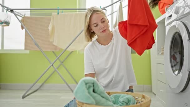 Çamaşır Odasında Yorgun Sepetin Üstünde Kıyafet Arayan Genç Sarışın Kadın — Stok video