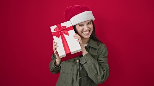 Jong Mooi Latino Vrouw Glimlachen Zelfverzekerd Holding Kerstcadeau Geïsoleerde Rood — Stockvideo