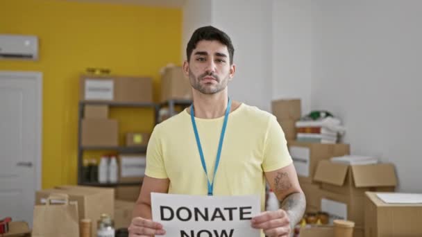 Junger Hispanischer Mann Lächelt Selbstbewusst Und Hält Spendenbanner Charity Zentrum — Stockvideo