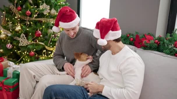 Dos Hombres Pareja Celebrando Navidad Sentado Sofá Con Perro Casa — Vídeo de stock