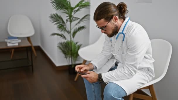 Ung Latinamerikansk Man Läkare Använder Smartphone Arbetar Kliniken Väntrum — Stockvideo