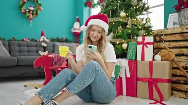 Mujer Rubia Joven Usando Smartphone Bebiendo Café Celebrando Navidad Casa — Vídeos de Stock