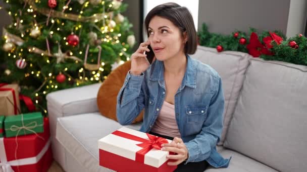 Kafkasyalı Genç Bir Kadın Evde Hediyesiyle Noel Ağacının Yanında Telefonda — Stok video