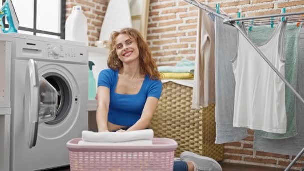 Çamaşır Odasında Yerde Oturmuş Kendinden Emin Gülümseyen Genç Bir Kadın — Stok video