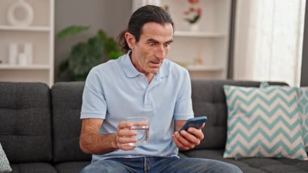 Middelbare Leeftijd Man Met Glas Water Met Behulp Van Smartphone — Stockvideo