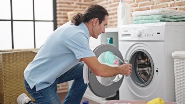 洗濯室で笑顔でテディベアを洗う中年男性 — ストック動画