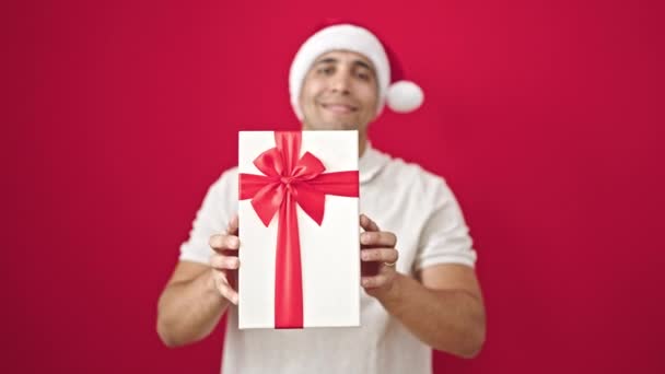 Jonge Spaanse Man Glimlachend Zelfverzekerd Houden Van Kerst Aanwezig Geïsoleerde — Stockvideo