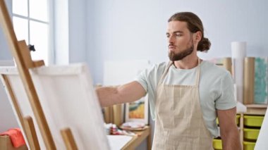 Young hispanic man artist smiling confident drawing at art studio