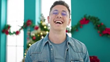 Genç İspanyol adam gülerek Noel 'i evde kutluyor.