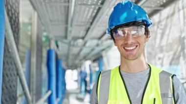 Genç İspanyol mimar inşaat alanında kendine güvenerek gülümsüyor.