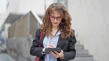 Sokakta dokunmatik ped kullanan genç bir iş kadını.