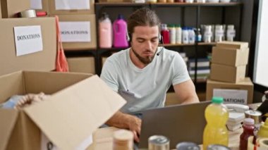 Yardım merkezinde gülümseyen dizüstü bilgisayar ve kulaklık kullanan İspanyol bir gönüllü.