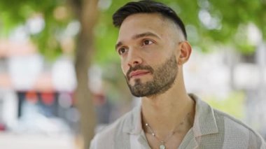 Parkta ciddi bir ifadeyle duran İspanyol genç adam.