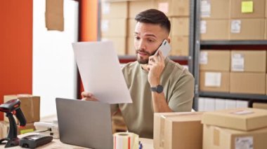 İspanyol asıllı genç iş adamı ofisteki akıllı telefon okuma belgeleriyle konuşuyor.