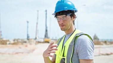 İnşaat alanında boyun ağrısı çeken genç İspanyol mimar.